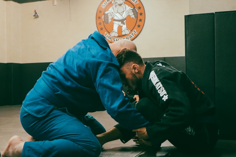 a man in a blue shirt and a man in a black jacket in a gym